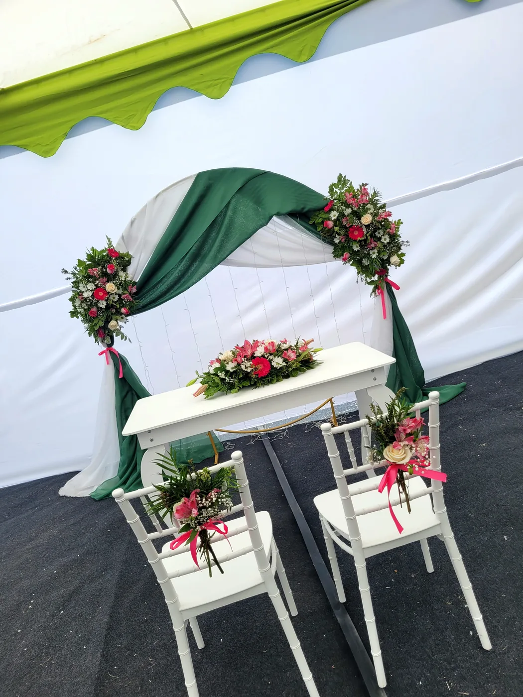 Arco redondo en fucsia y coral bajo carpa